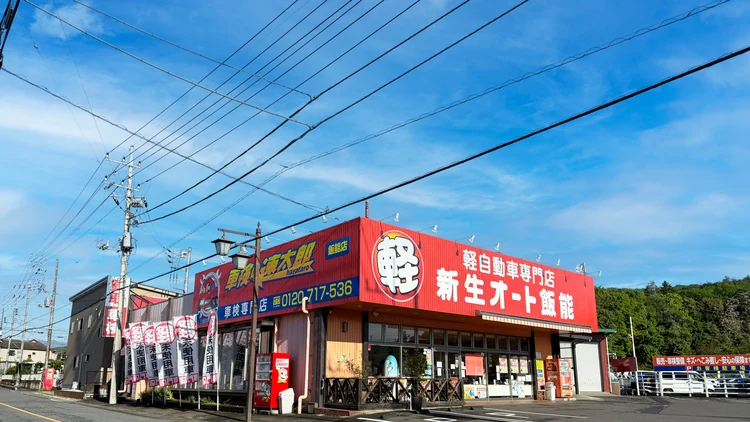 赤い看板が目印の新生オート飯能の店舗外観
